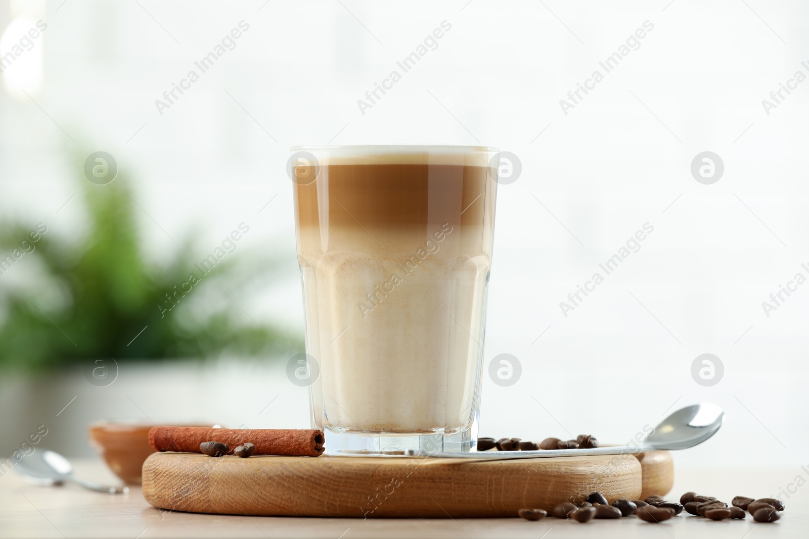 Photo of Tasty latte macchiato in glass on wooden table, closeup