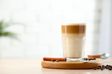 Photo of Tasty latte macchiato in glass on wooden table, space for text