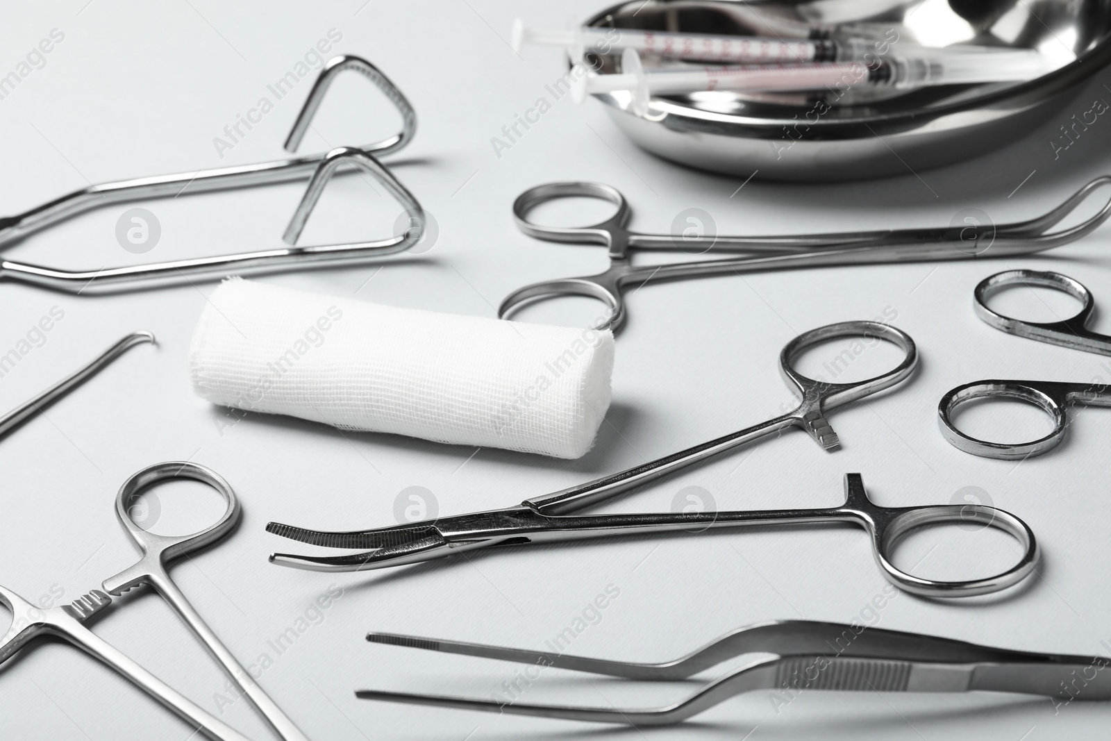 Photo of Different surgical instruments on light grey background, closeup