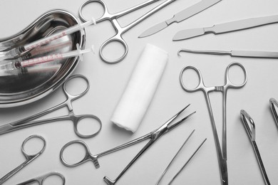 Photo of Different surgical instruments on light grey background, flat lay