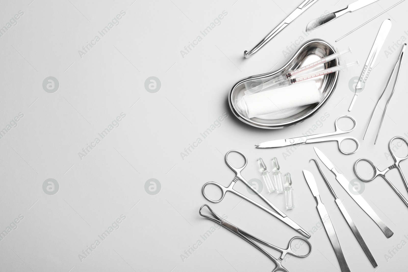 Photo of Different surgical instruments on light grey background, flat lay. Space for text