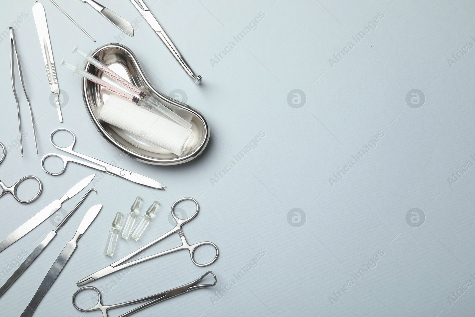 Photo of Different surgical instruments on light grey background, flat lay. Space for text