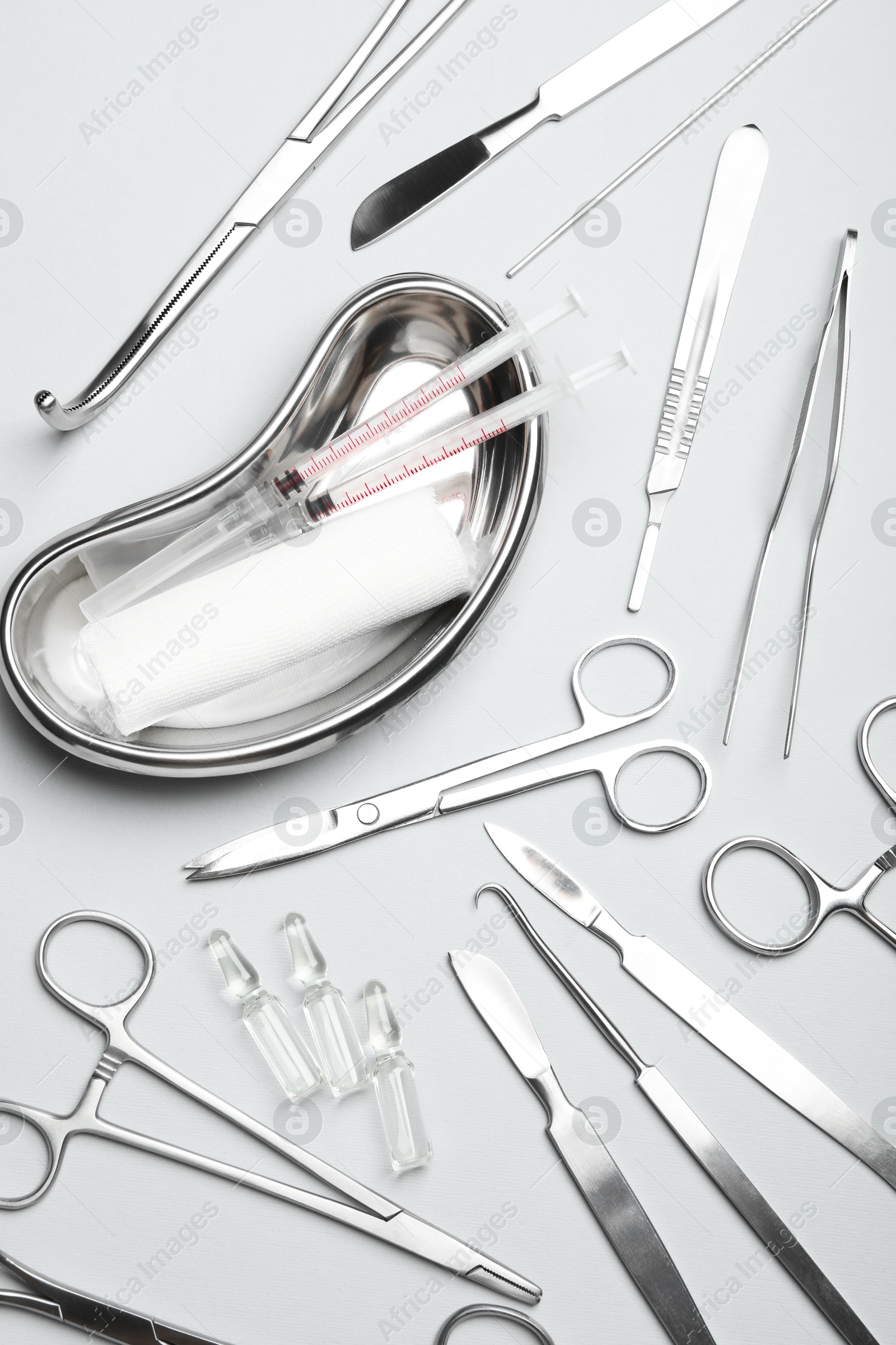 Photo of Different surgical instruments on light grey background, flat lay