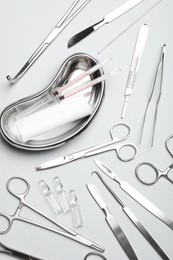 Different surgical instruments on light grey background, flat lay