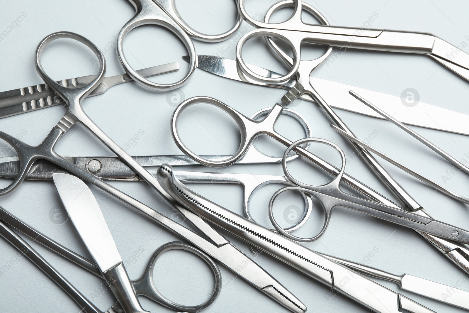 Photo of Different surgical instruments on light grey background, flat lay