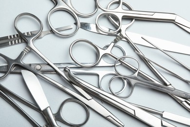 Different surgical instruments on light grey background, flat lay