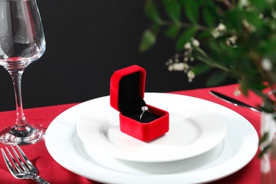 Beautiful engagement ring and setting for romantic dinner on red table