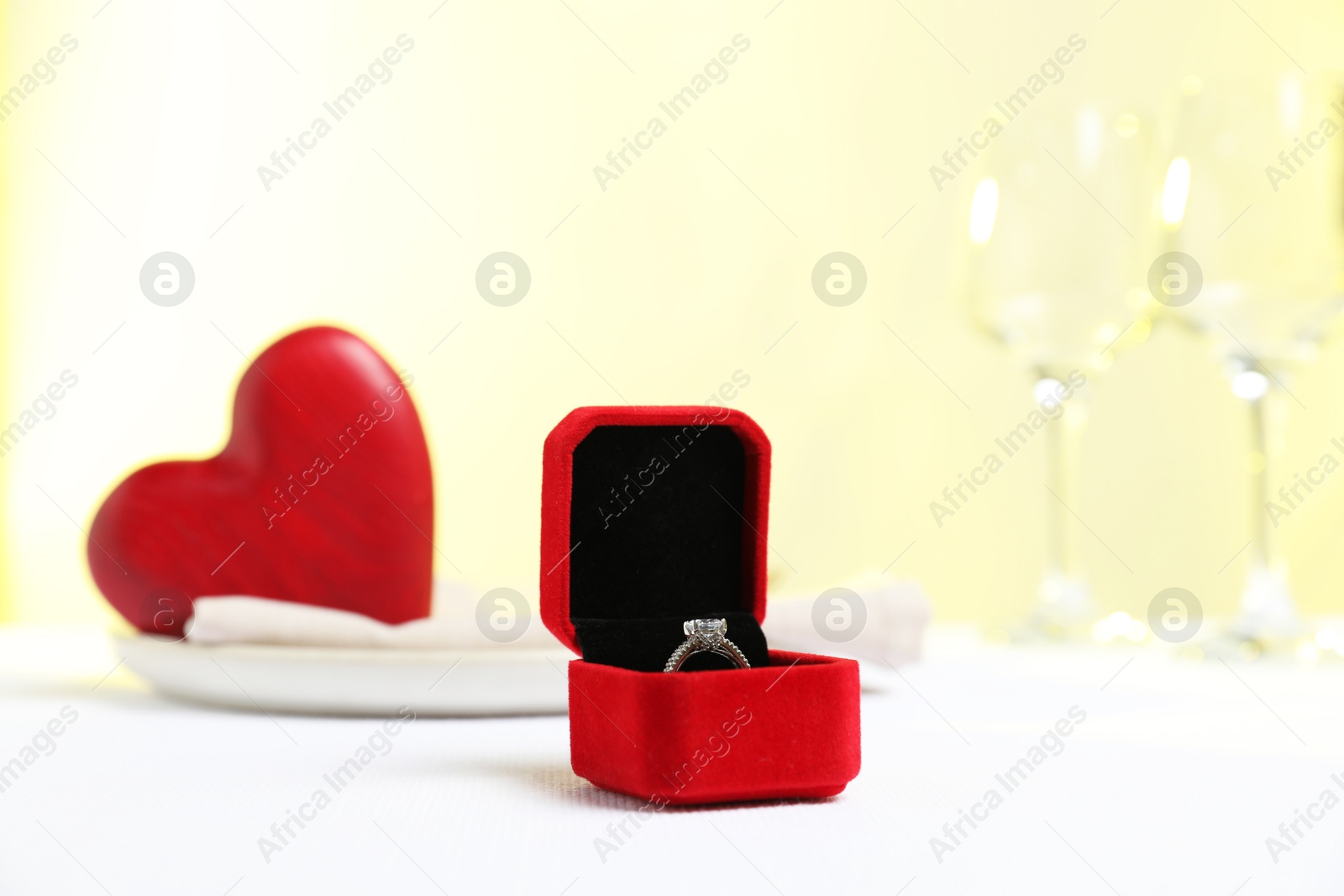 Photo of Beautiful engagement ring and setting for romantic dinner on white table