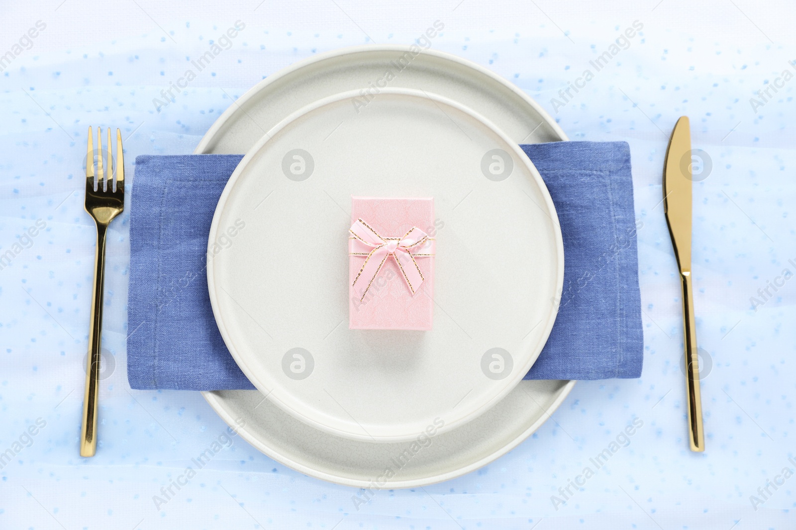 Photo of Gift and setting for romantic dinner on light background, top view