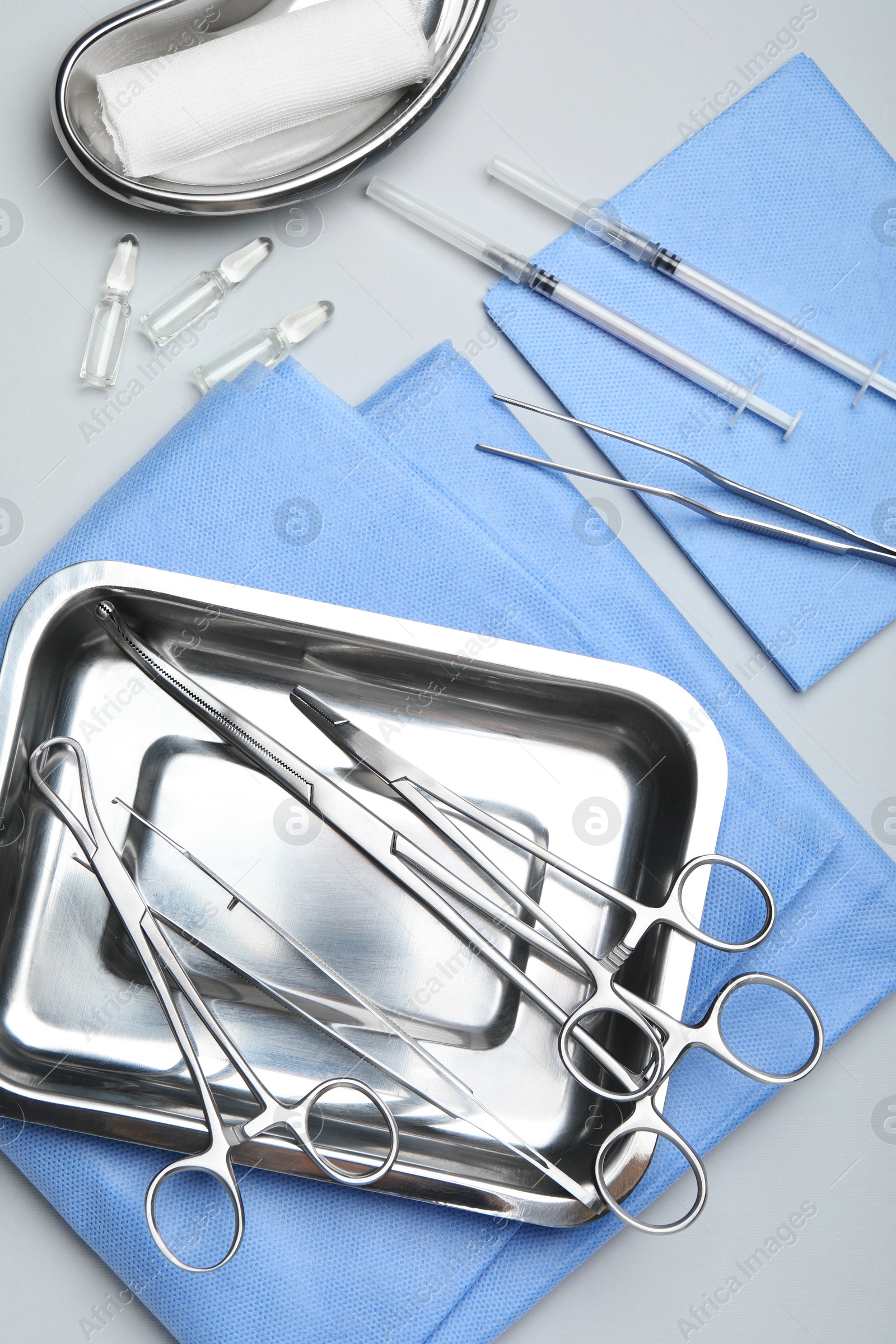 Photo of Different surgical tools on light gray background, flat lay