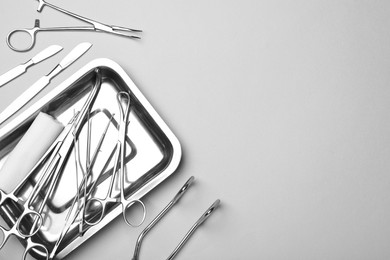 Photo of Different surgical tools on light gray background, flat lay. Space for text