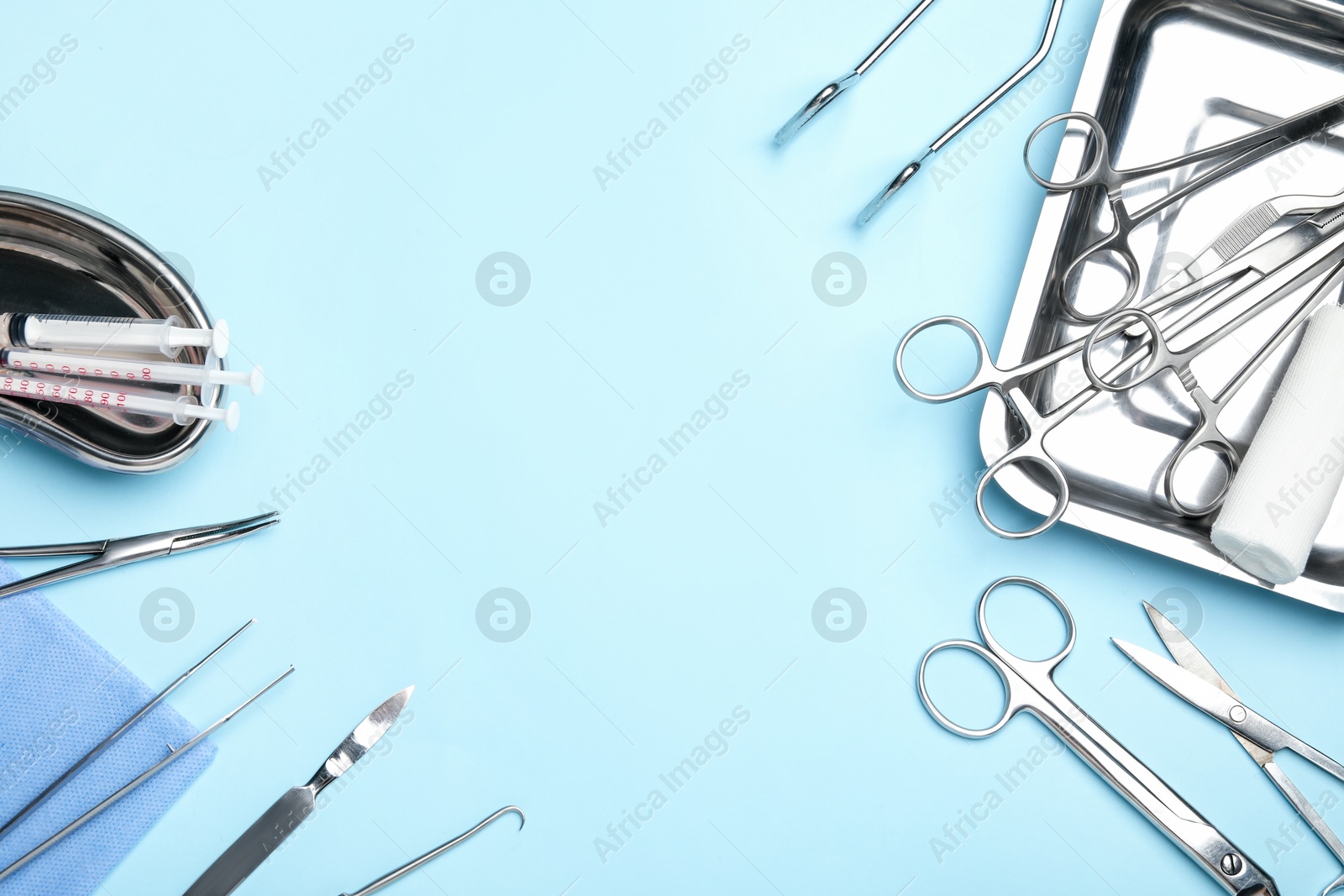 Photo of Different surgical tools on light blue background, flat lay. Space for text