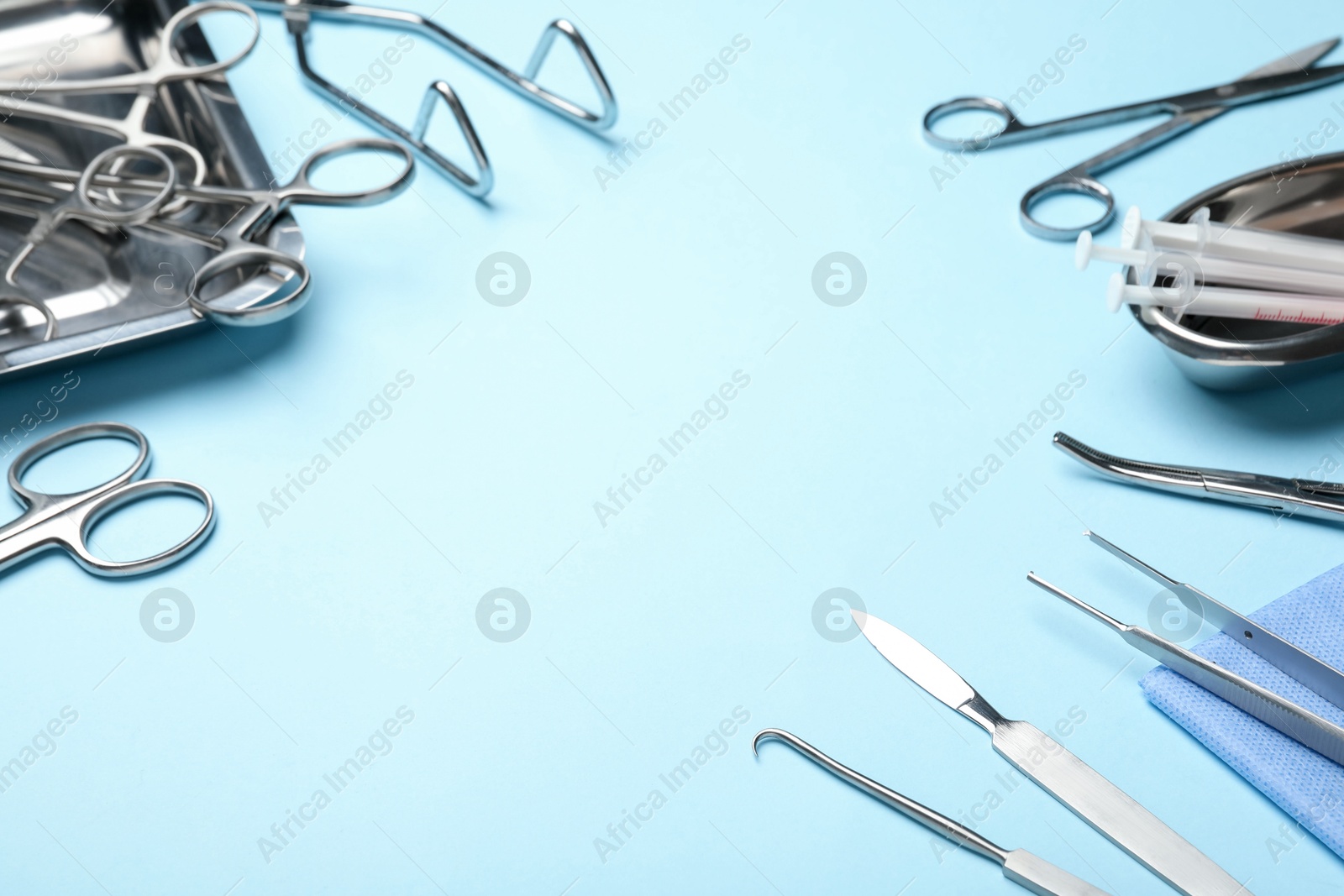 Photo of Different surgical tools on light blue background, closeup. Space for text