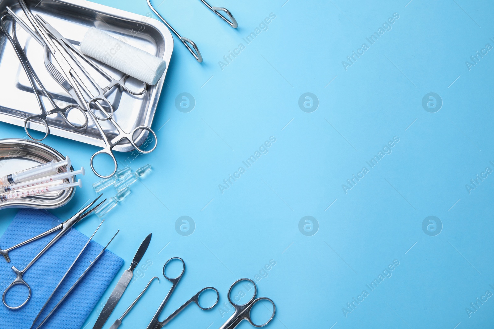 Photo of Different surgical tools on light blue background, flat lay. Space for text