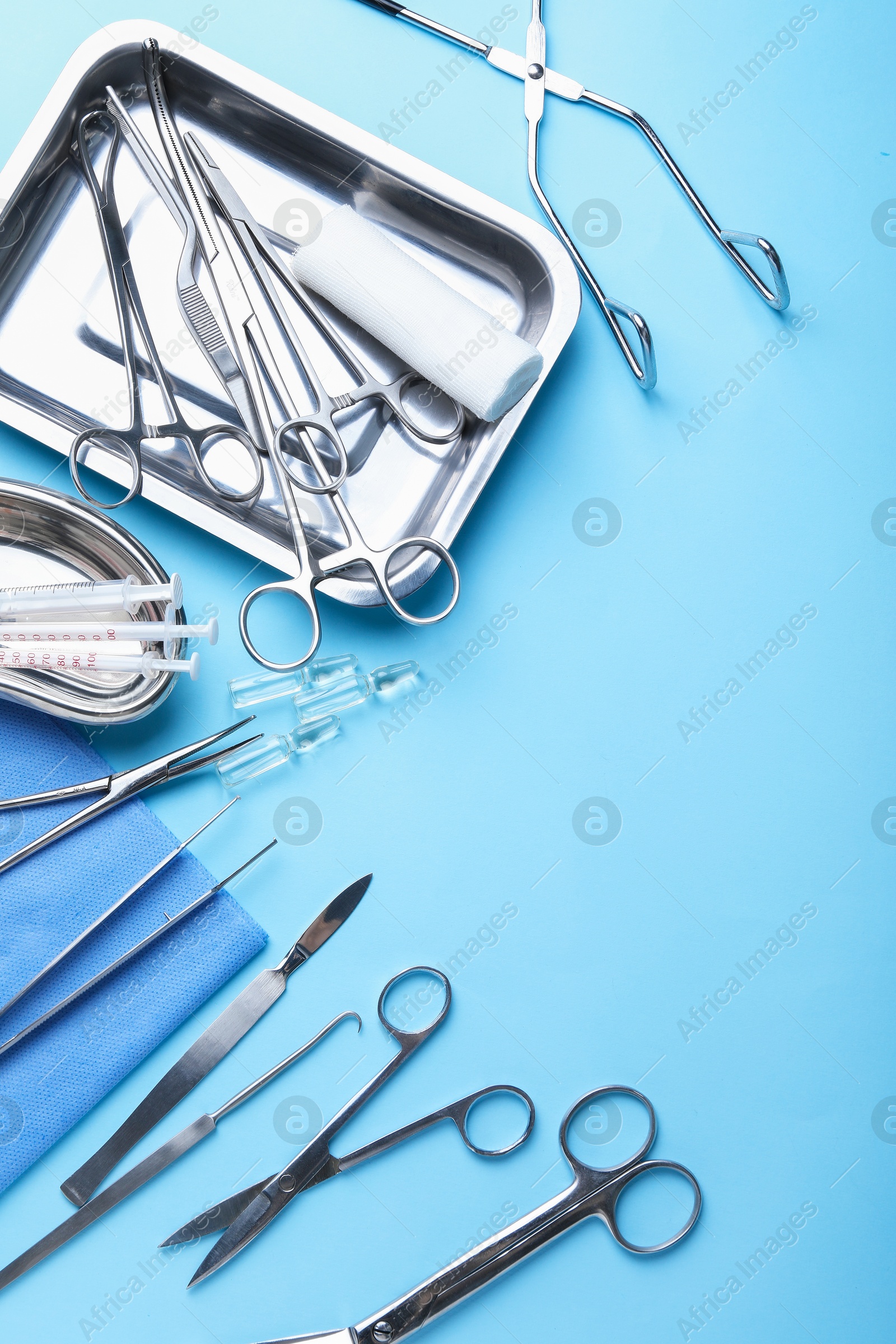 Photo of Different surgical tools on light blue background, flat lay. Space for text