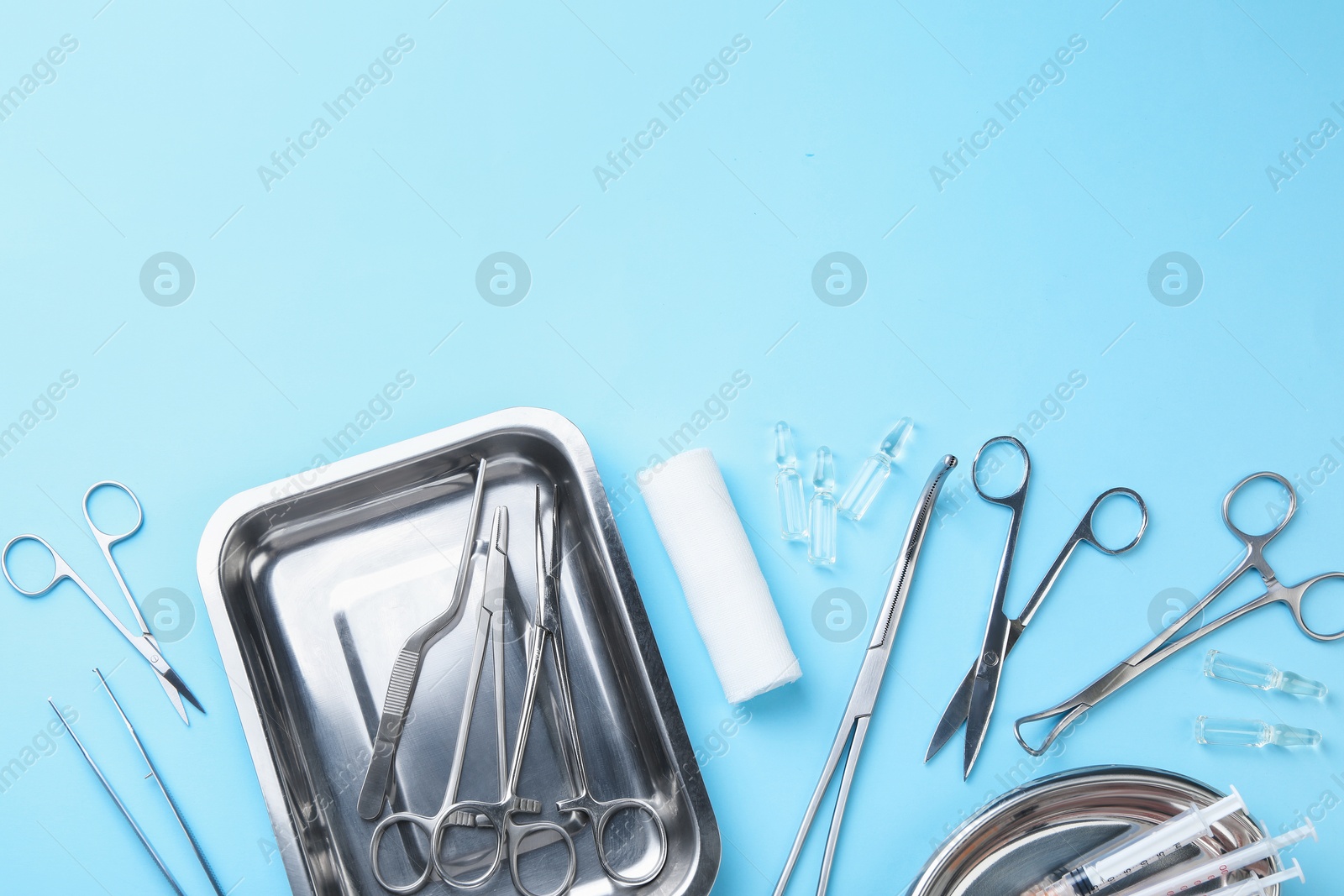 Photo of Different surgical tools on light blue background, flat lay. Space for text