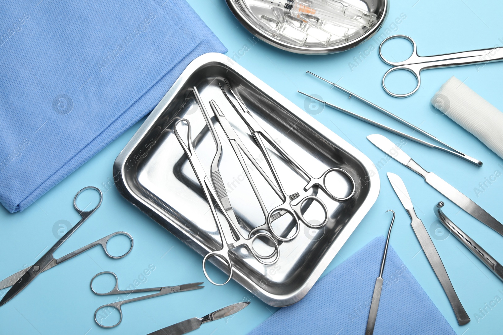 Photo of Different surgical tools on light blue background, flat lay