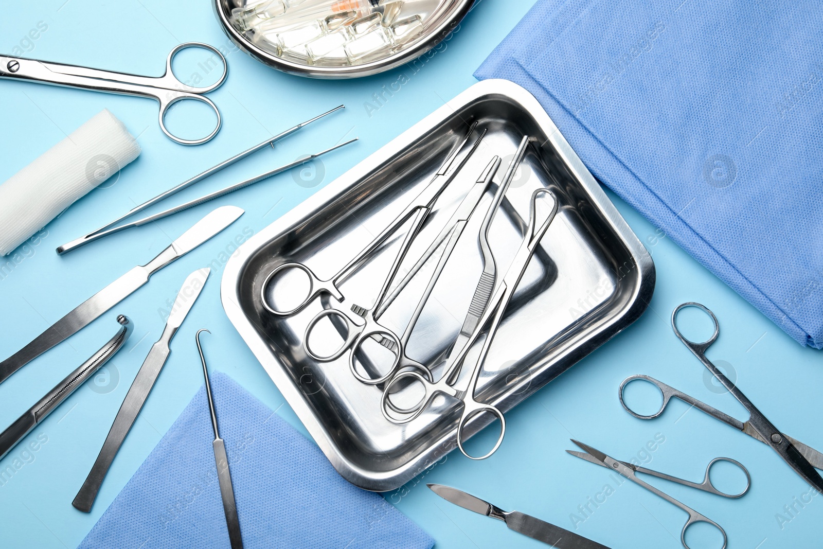 Photo of Different surgical tools on light blue background, flat lay