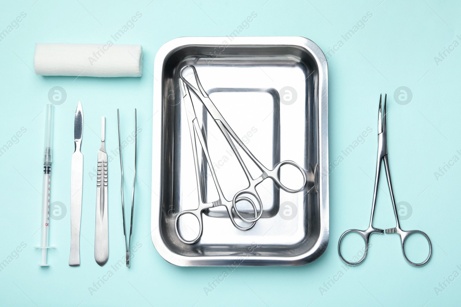 Photo of Different surgical tools on turquoise background, flat lay