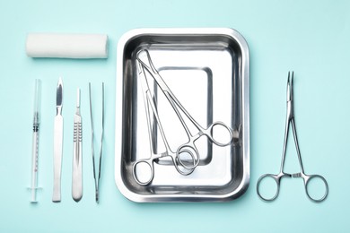 Different surgical tools on turquoise background, flat lay