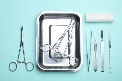 Photo of Different surgical tools on turquoise background, flat lay