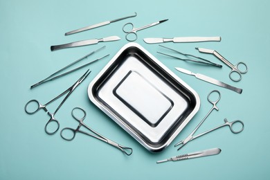 Photo of Different surgical tools on turquoise background, flat lay