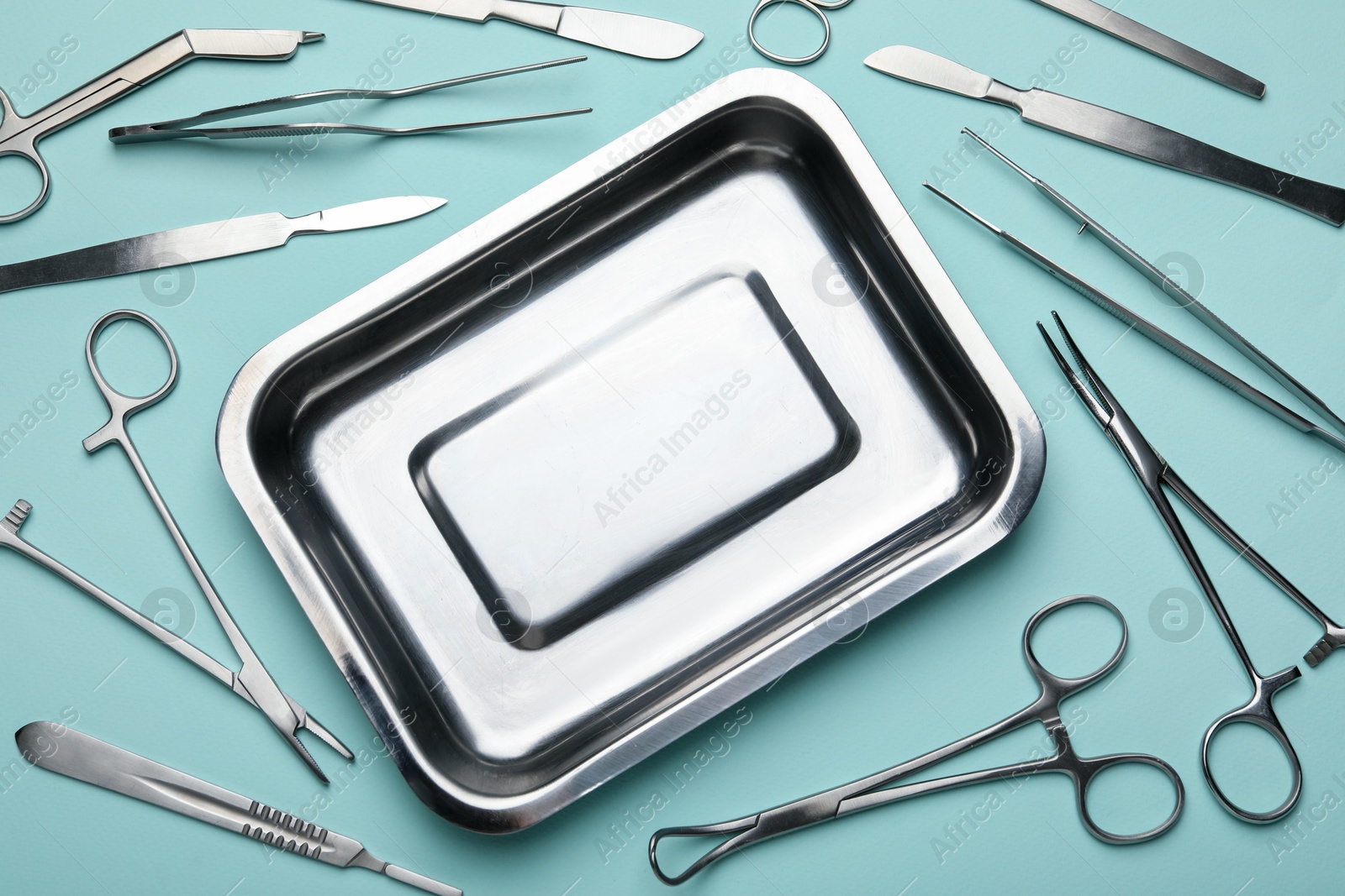 Photo of Different surgical tools on turquoise background, flat lay