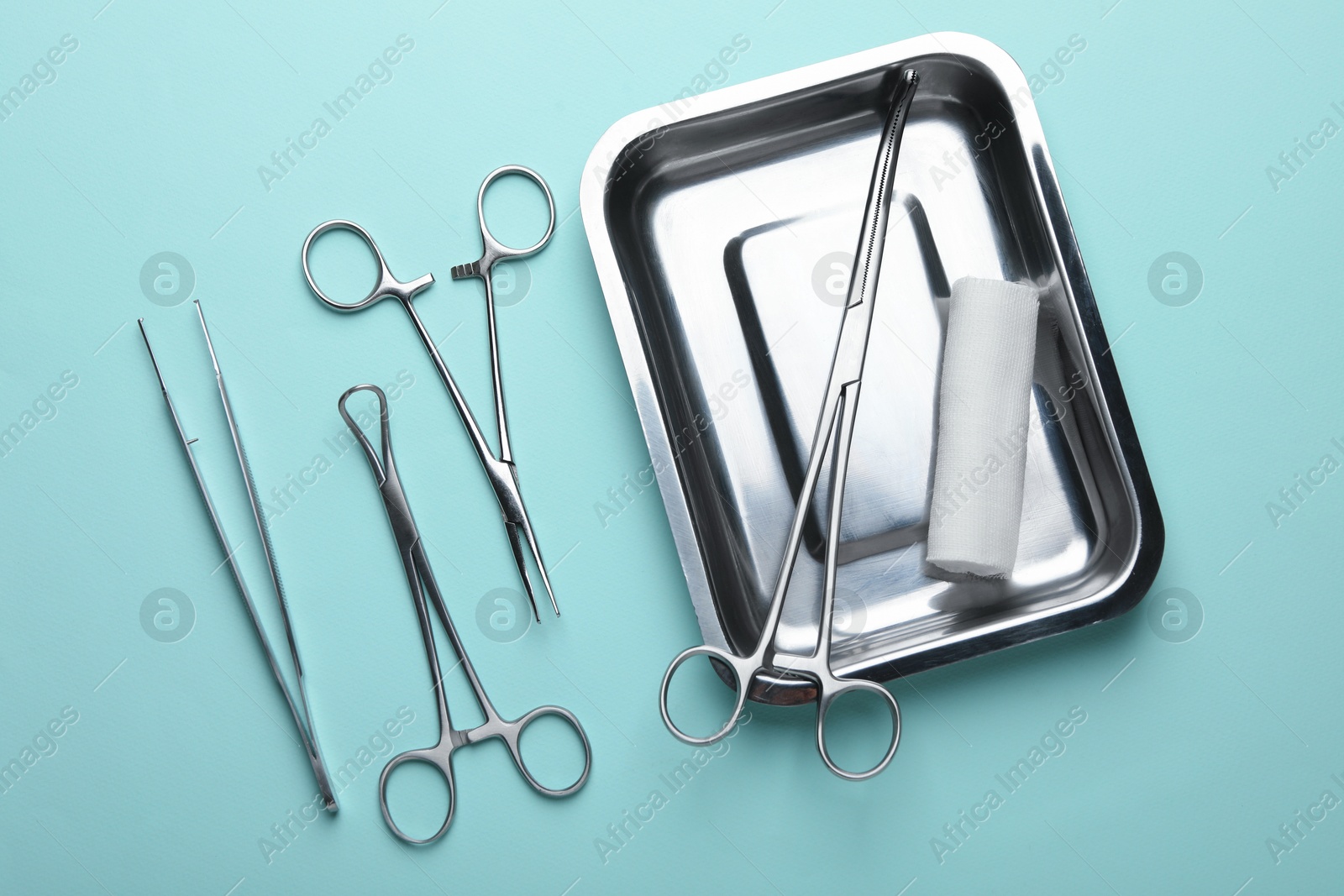 Photo of Different surgical tools on turquoise background, flat lay