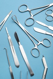 Photo of Different surgical tools on light blue background, flat lay