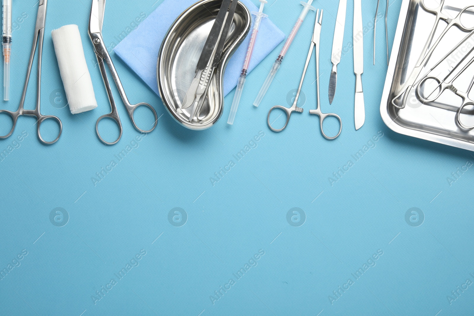 Photo of Different surgical tools on light blue background, flat lay. Space for text