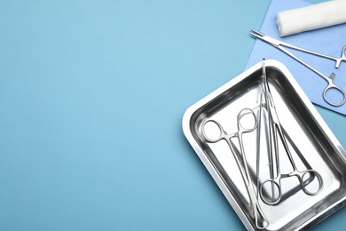 Photo of Different surgical tools on light blue background, flat lay. Space for text