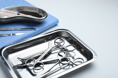 Photo of Different surgical tools on light gray background, closeup