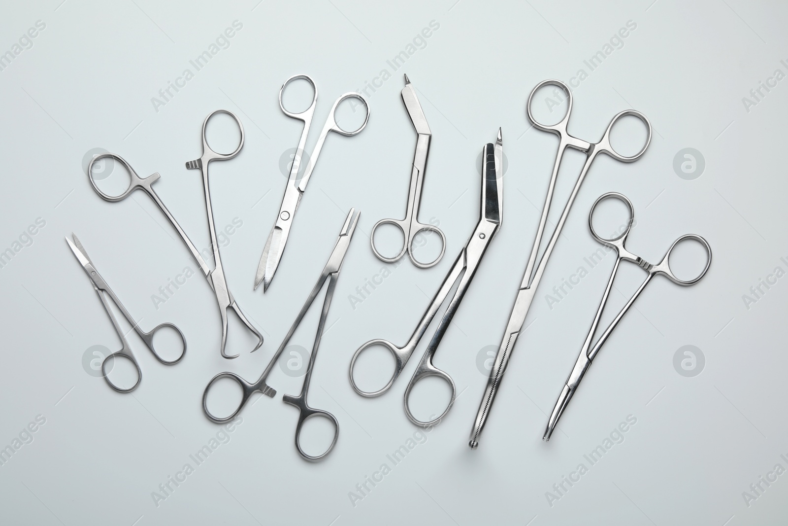 Photo of Different surgical tools on light gray background, flat lay