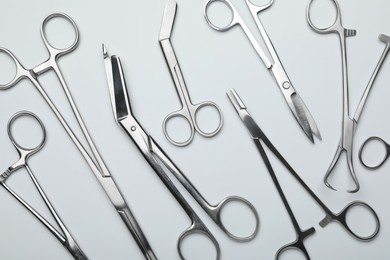 Photo of Different surgical tools on light gray background, flat lay