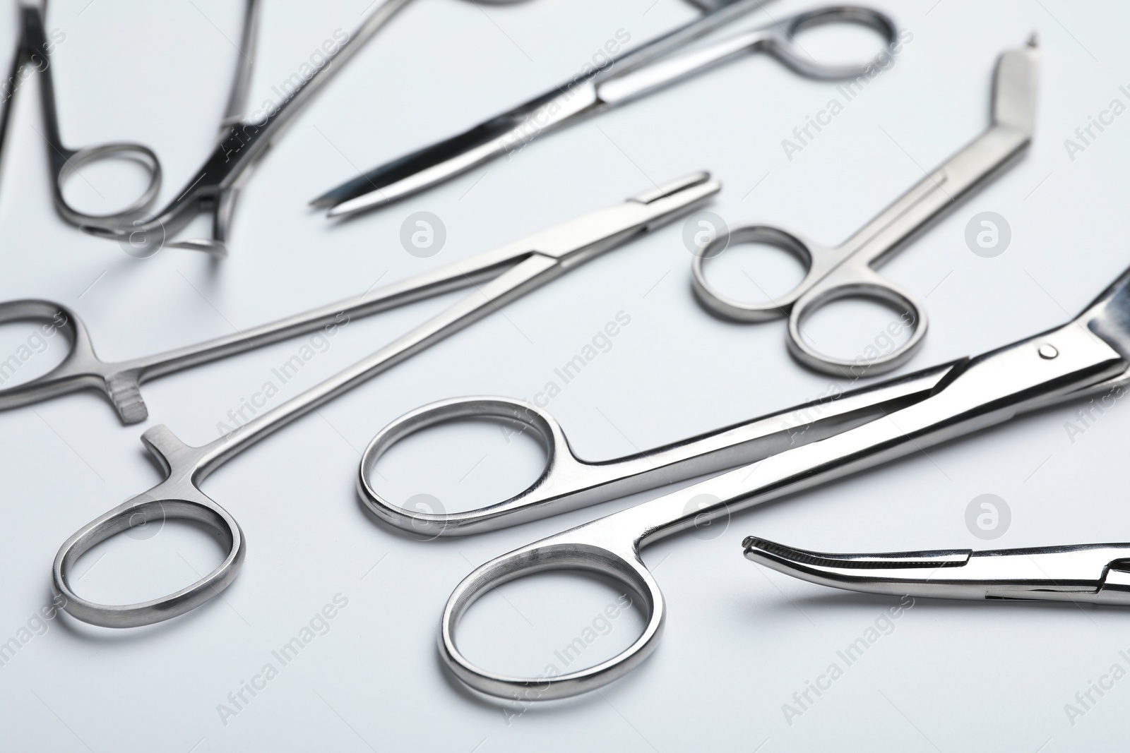 Photo of Different surgical tools on light gray background, closeup