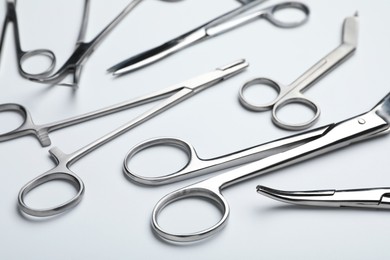 Photo of Different surgical tools on light gray background, closeup