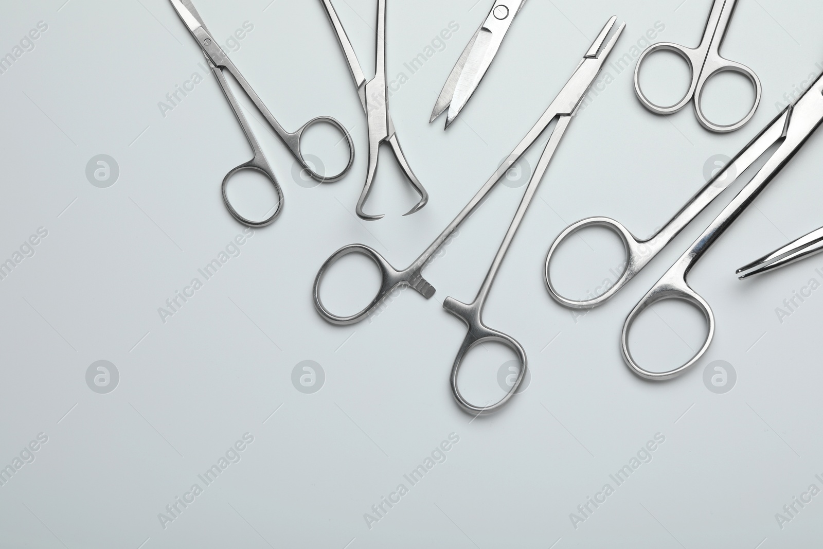 Photo of Different surgical tools on light gray background, flat lay. Space for text