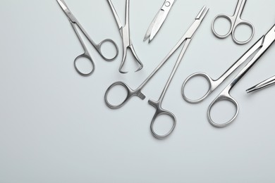 Photo of Different surgical tools on light gray background, flat lay. Space for text