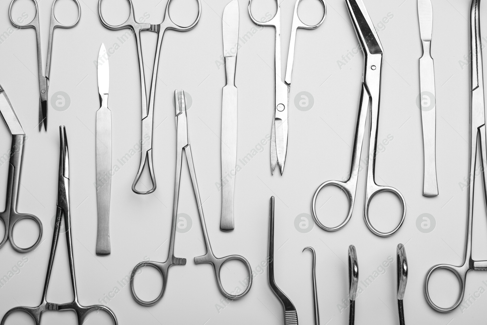 Photo of Different surgical tools on light gray background, flat lay