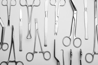 Photo of Different surgical tools on light gray background, flat lay