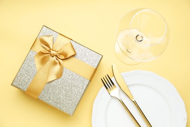 Beautiful table setting with romantic gift on beige background, flat lay