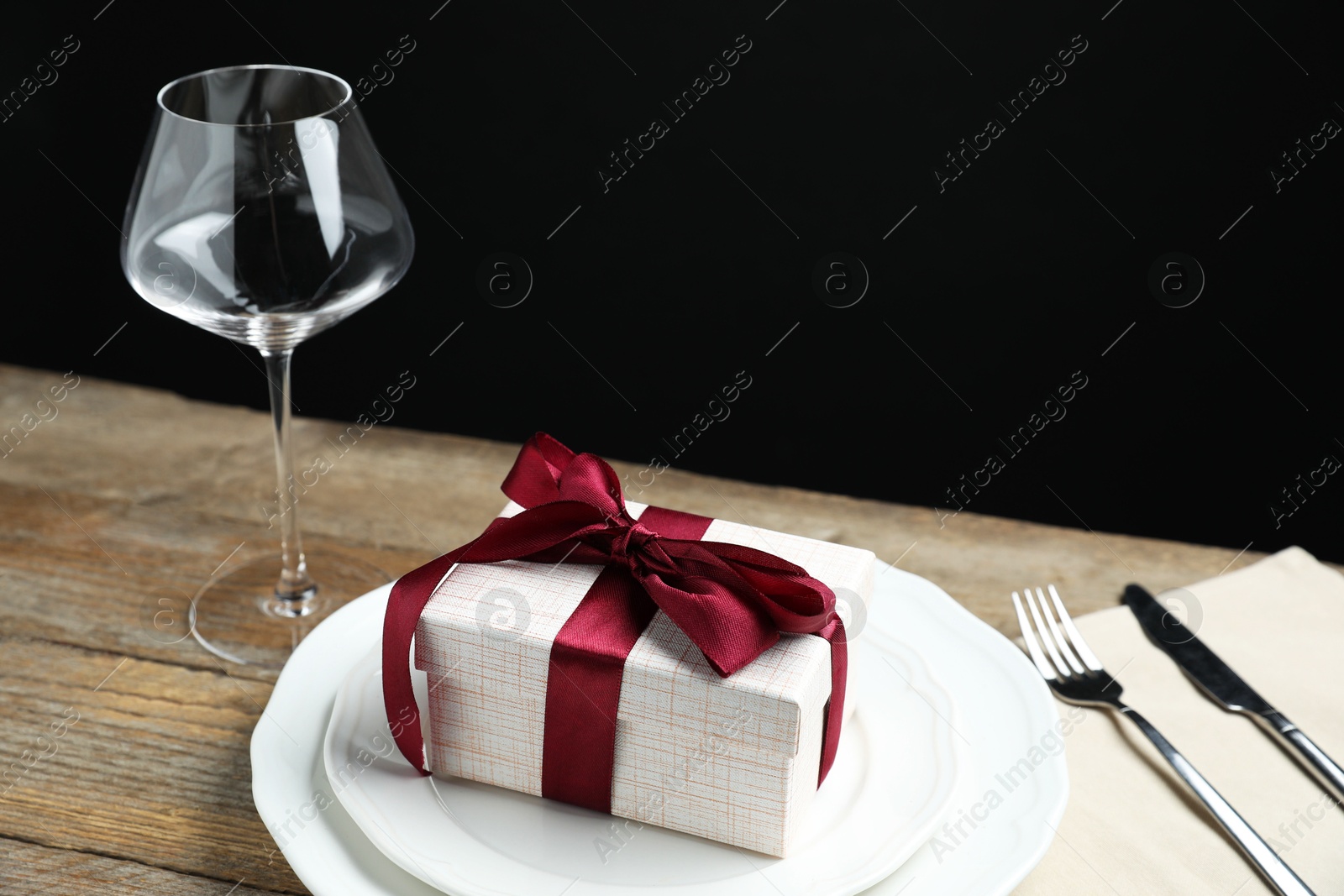 Photo of Beautiful table setting with romantic gift on wooden background