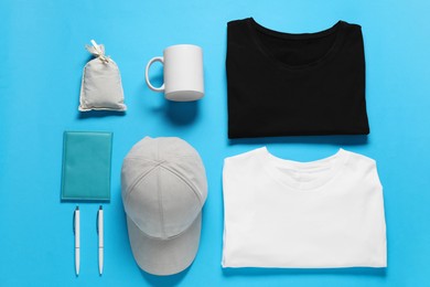 Photo of Different blank items for branding on light blue background, flat lay. Mockup for design