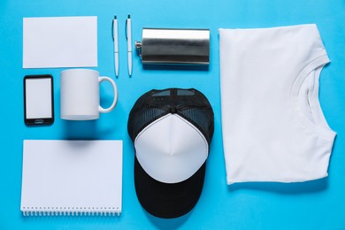 Photo of Different blank items for branding on light blue background, flat lay. Mockup for design