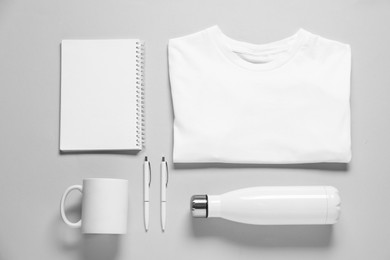 Photo of Different blank items for branding on grey background, flat lay. Mockup for design