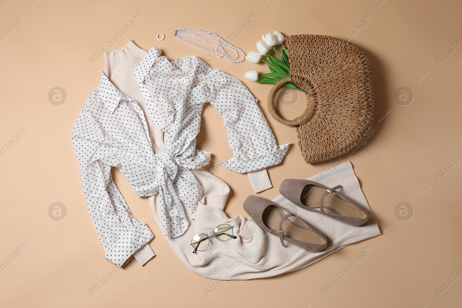 Elegant women's outfit. Stylish clothes and accessories on beige background, flat lay Photo of Elegant women's outfit. Stylish clothes and accessories on beige background, flat lay