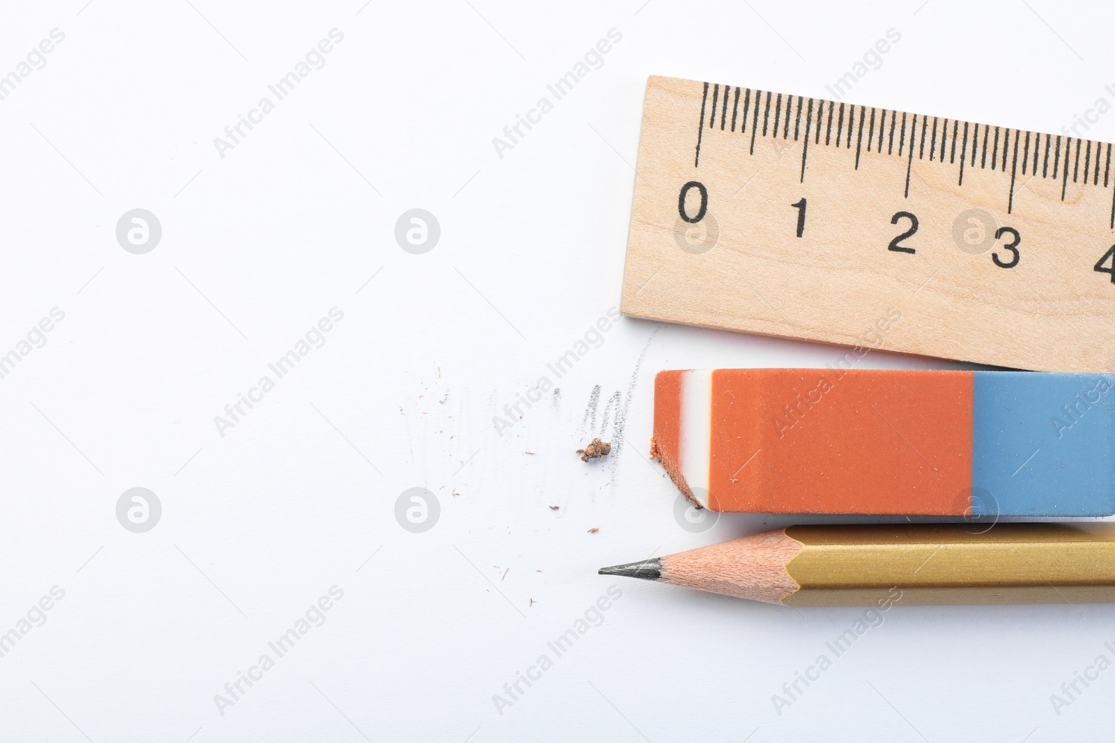 Photo of Eraser, ruler and pencil on white background, flat lay. Space for text