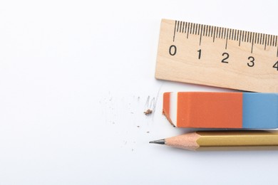 Photo of Eraser, ruler and pencil on white background, flat lay. Space for text