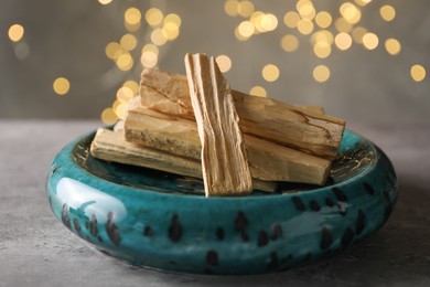 Photo of Palo santo sticks on grey table, closeup