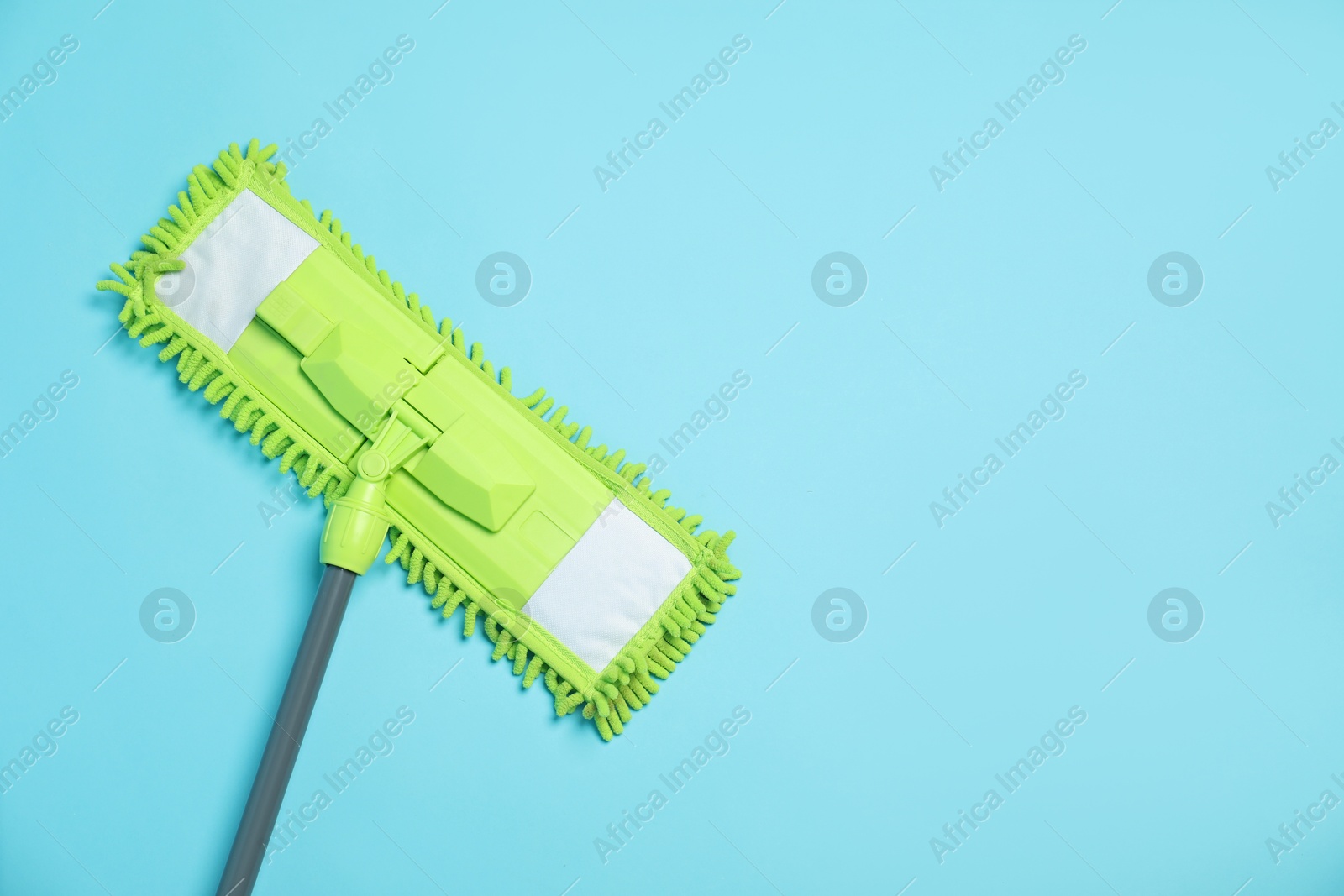 Photo of Microfiber mop on light blue background, top view. Space for text